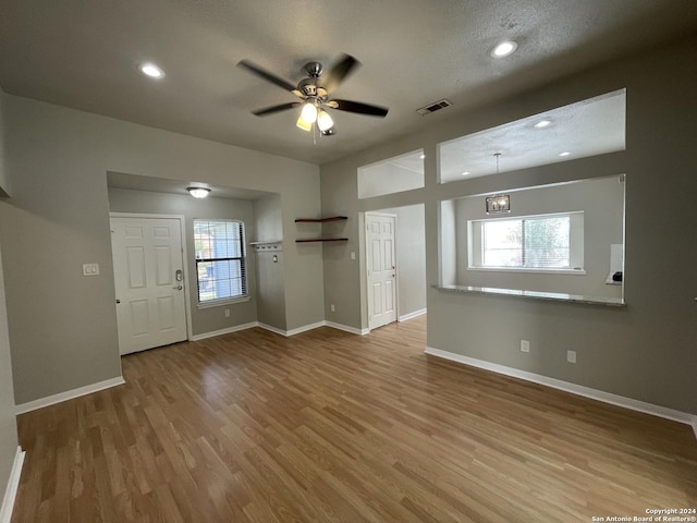 interior space with ceiling fan, light hardwood / wood-style floors, and a textured ceiling