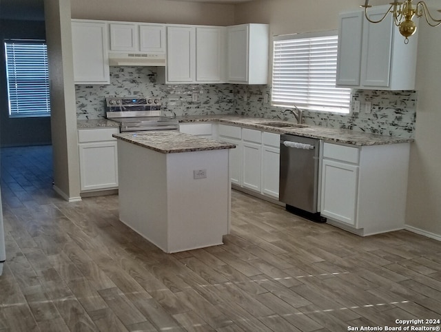 kitchen with stainless steel appliances, white cabinetry, custom exhaust hood, sink, and a kitchen island