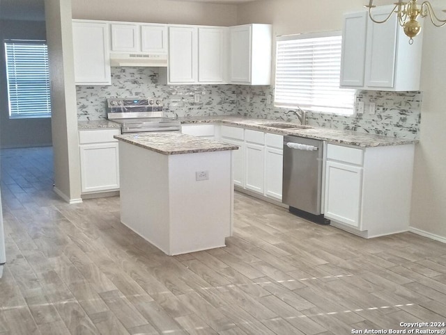 kitchen with a kitchen island, appliances with stainless steel finishes, white cabinetry, sink, and light hardwood / wood-style flooring