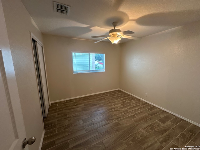 spare room with ceiling fan and dark wood-type flooring