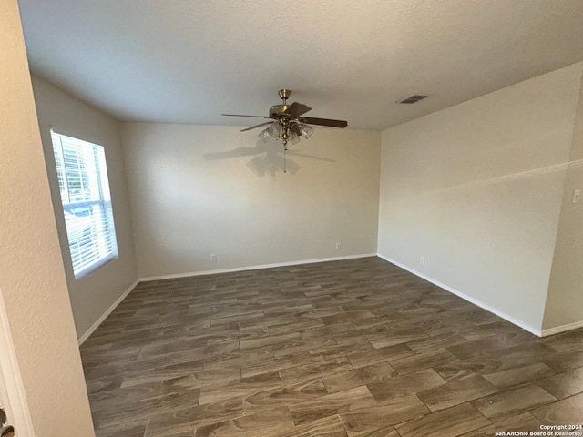 spare room with ceiling fan, dark hardwood / wood-style floors, and a textured ceiling