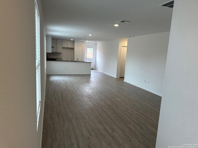 unfurnished living room with dark wood-type flooring