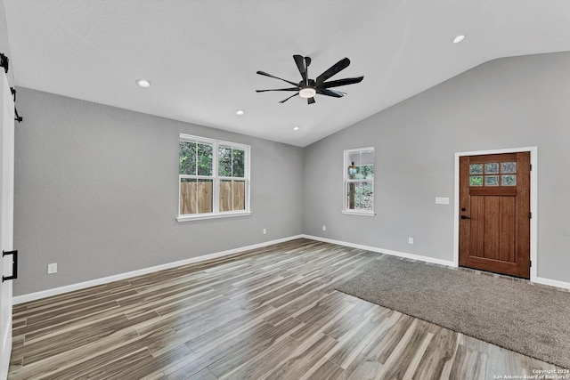 interior space featuring lofted ceiling, ceiling fan, hardwood / wood-style flooring, and a healthy amount of sunlight