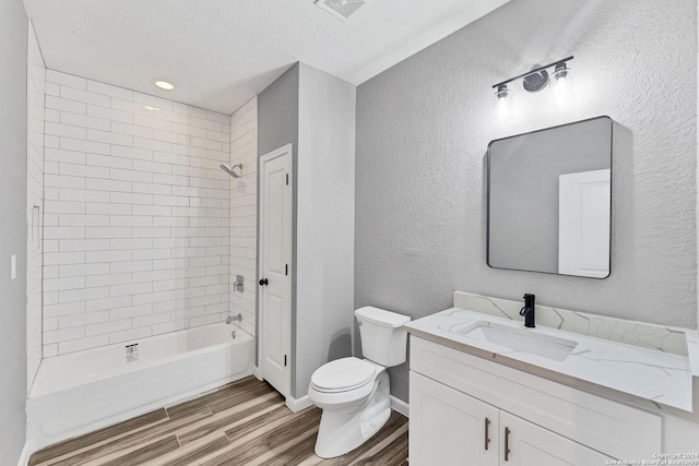 full bathroom with tiled shower / bath combo, wood-type flooring, vanity, and toilet