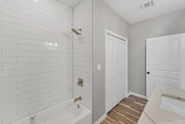 bathroom with vanity, tiled shower / bath combo, and hardwood / wood-style flooring