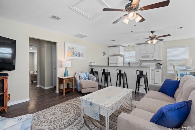 living room featuring sink, dark wood-type flooring, and ceiling fan