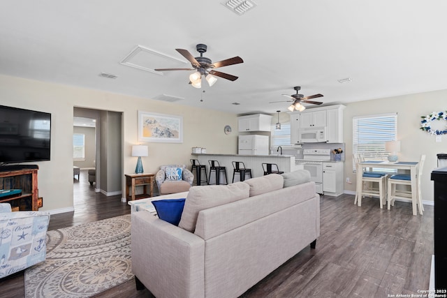 living room featuring hardwood / wood-style flooring, sink, and ceiling fan