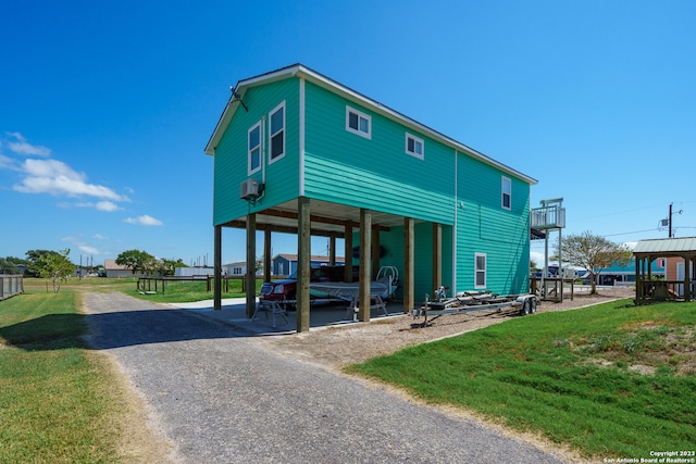 back of house with a balcony and a lawn