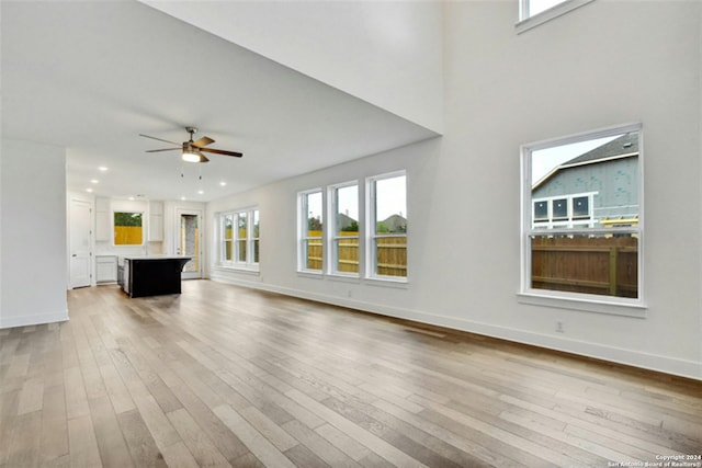 unfurnished living room featuring ceiling fan and light hardwood / wood-style flooring