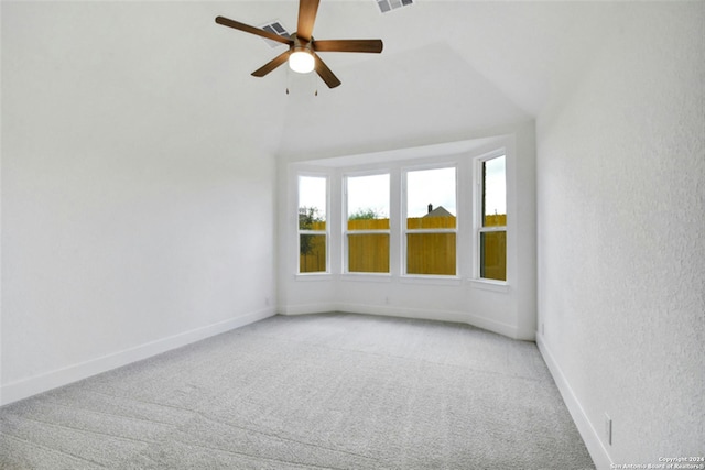 empty room with lofted ceiling, light carpet, and ceiling fan