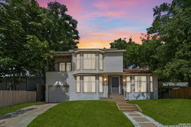 view of front of house featuring a garage and a yard