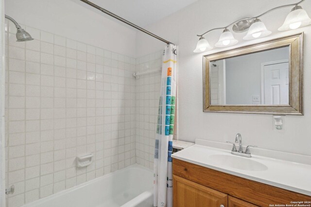 bathroom featuring shower / bath combo with shower curtain and vanity