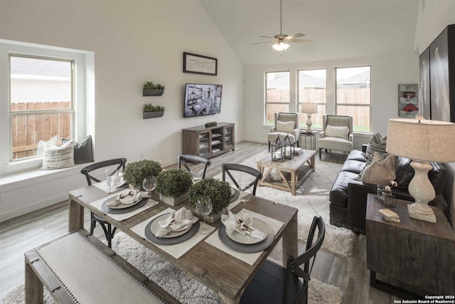 living room with ceiling fan, hardwood / wood-style flooring, and high vaulted ceiling