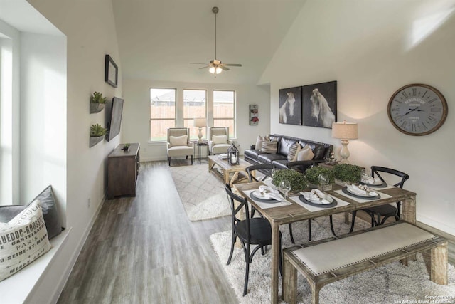 dining space with high vaulted ceiling, ceiling fan, and hardwood / wood-style flooring