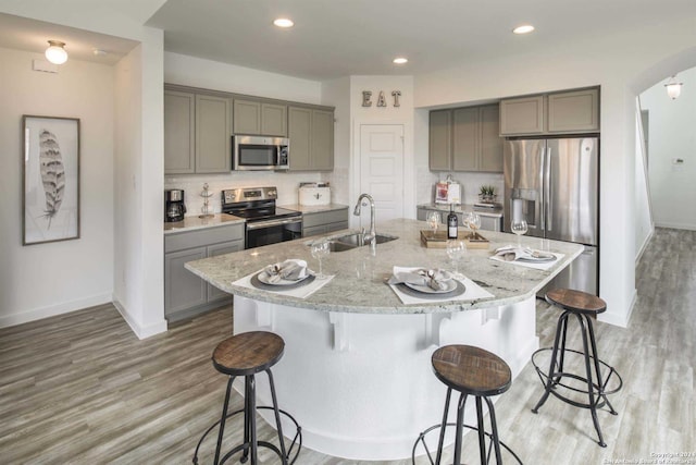 kitchen featuring a large island, light wood-type flooring, sink, a kitchen bar, and stainless steel appliances