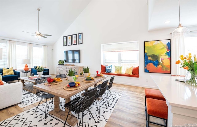 dining space featuring ceiling fan, light hardwood / wood-style flooring, plenty of natural light, and high vaulted ceiling