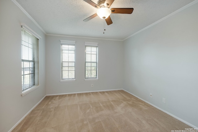 carpeted spare room with a textured ceiling, ceiling fan, plenty of natural light, and crown molding