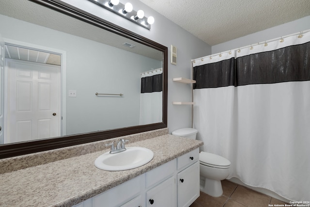 bathroom with vanity, toilet, tile patterned floors, and a textured ceiling