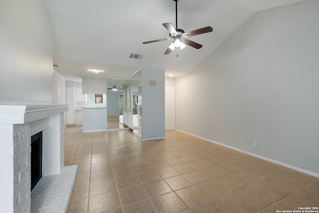 unfurnished living room with a fireplace, ceiling fan, lofted ceiling, and light tile patterned floors