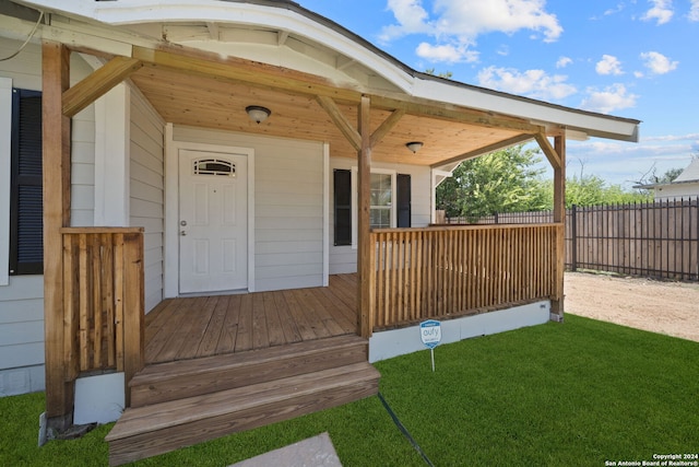 doorway to property with a yard and fence