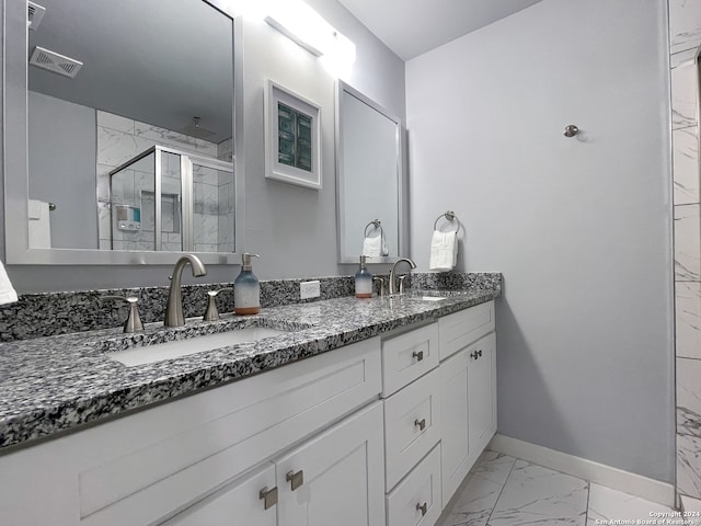 bathroom featuring dual vanity, a shower with shower door, and tile patterned floors