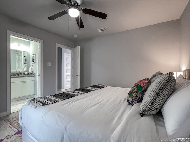 bedroom with light tile patterned flooring, ensuite bathroom, and ceiling fan