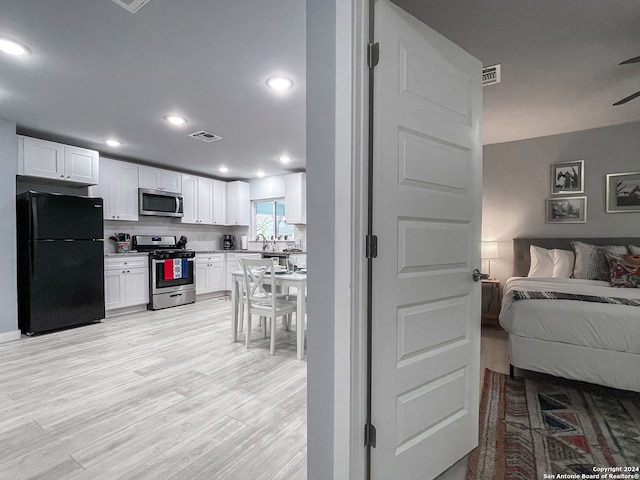 interior space featuring light hardwood / wood-style flooring and black fridge