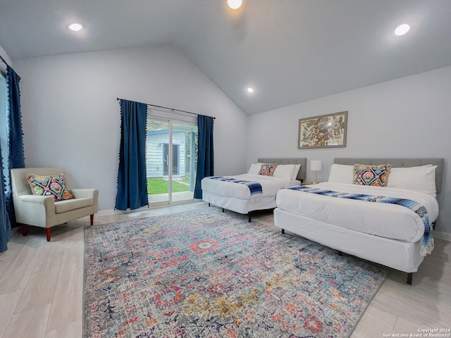 bedroom featuring light wood-type flooring, lofted ceiling, and access to exterior