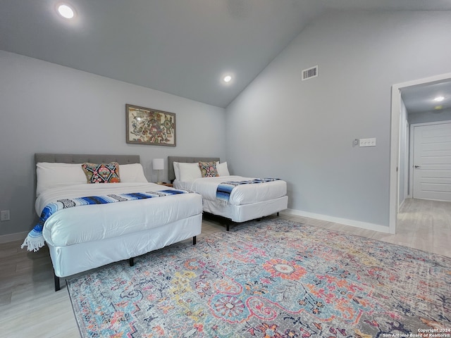 bedroom featuring high vaulted ceiling and light wood-type flooring