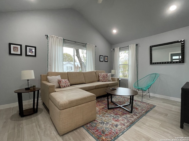 living room with light hardwood / wood-style floors and high vaulted ceiling