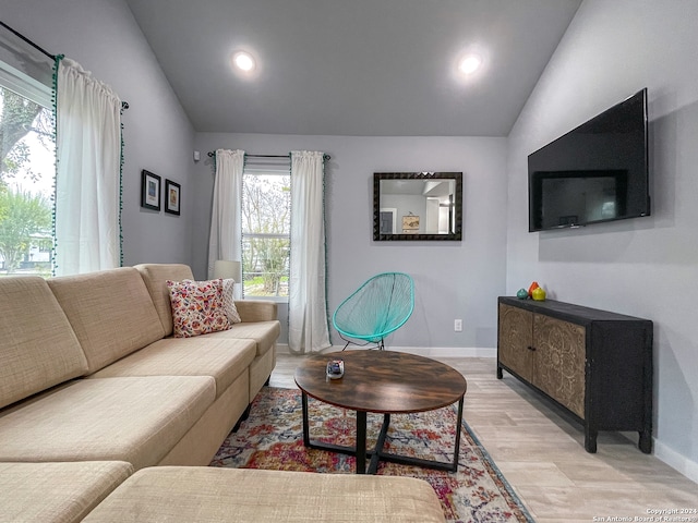 living room with light hardwood / wood-style floors and vaulted ceiling