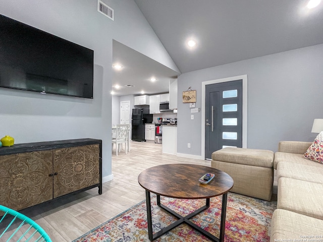 living room featuring light hardwood / wood-style flooring and high vaulted ceiling