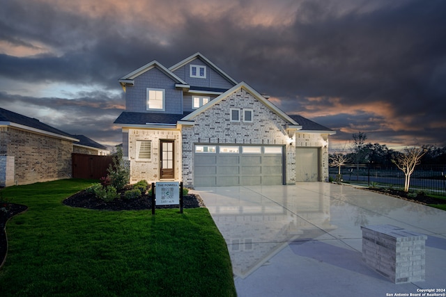 view of front of home with a garage and a lawn