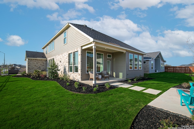 rear view of property featuring a patio area and a lawn