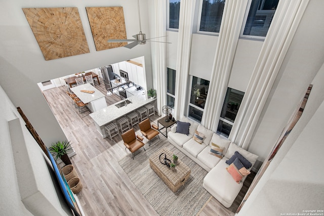 living room featuring ceiling fan, hardwood / wood-style flooring, and a high ceiling