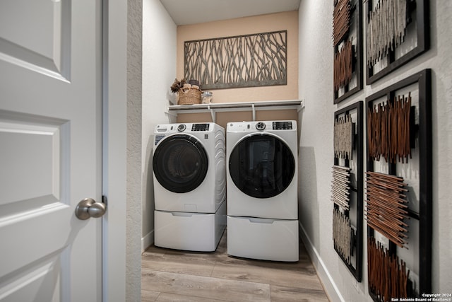 laundry room featuring light hardwood / wood-style floors and washing machine and dryer