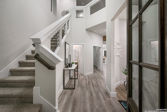 entrance foyer with light hardwood / wood-style flooring and a high ceiling