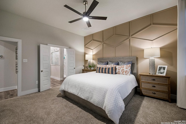 carpeted bedroom with ensuite bath and ceiling fan