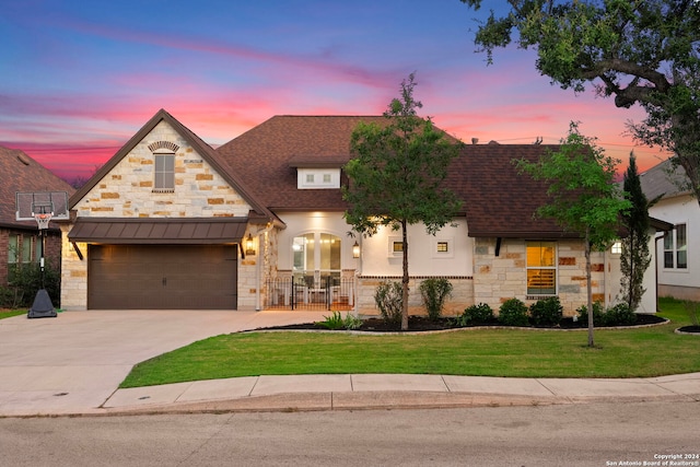 view of front of property featuring a lawn and a garage