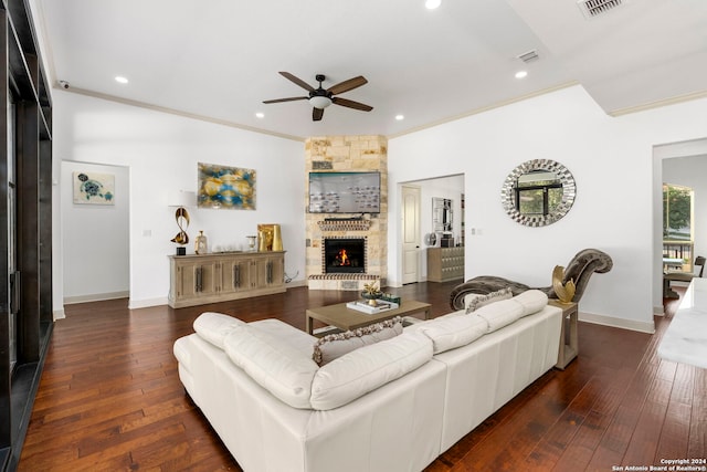 living room featuring ceiling fan, a large fireplace, ornamental molding, and dark hardwood / wood-style floors