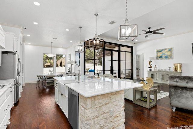 kitchen featuring a kitchen island with sink, pendant lighting, stainless steel appliances, and white cabinets