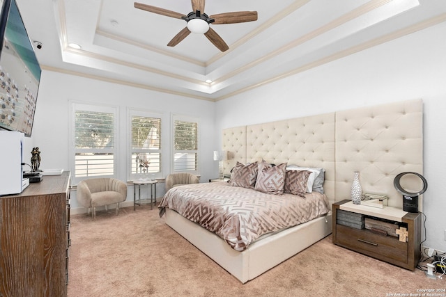 bedroom with a raised ceiling, crown molding, light colored carpet, and ceiling fan