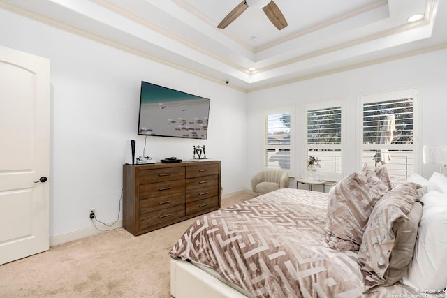 carpeted bedroom with crown molding, a tray ceiling, and ceiling fan