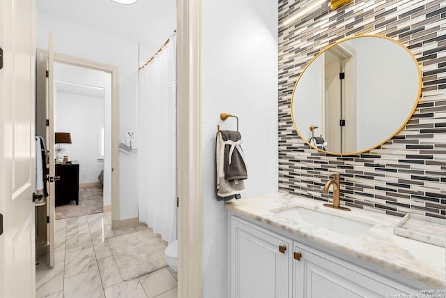 bathroom with vanity, toilet, and decorative backsplash