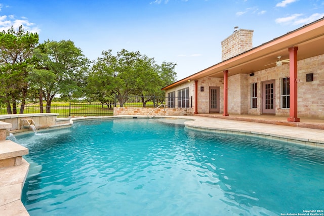 view of pool with a patio area, pool water feature, and french doors