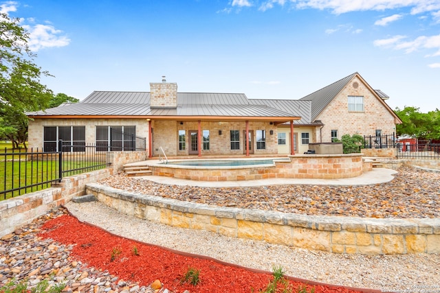 back of property with a patio and a hot tub