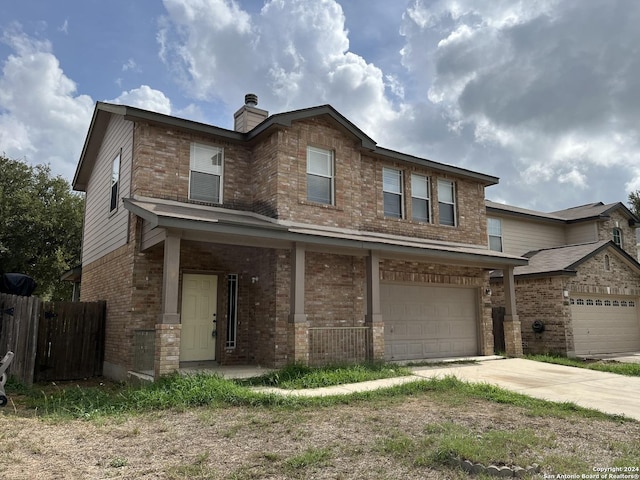 view of front of home with a garage, concrete driveway, a chimney, fence, and brick siding