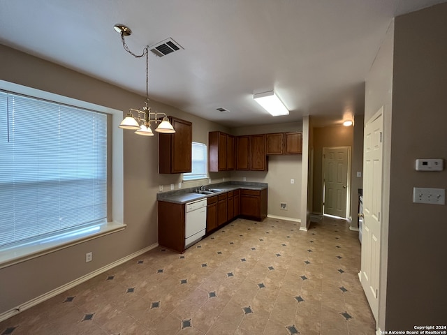 kitchen with hanging light fixtures, sink, light tile patterned flooring, and white dishwasher