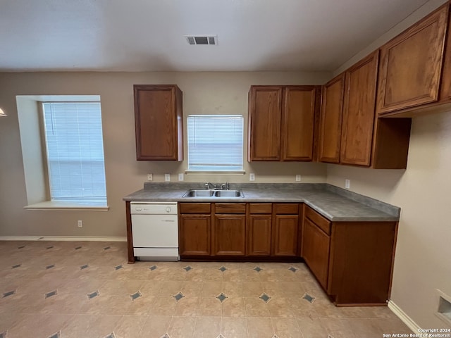 kitchen with sink, white dishwasher, and light tile patterned floors