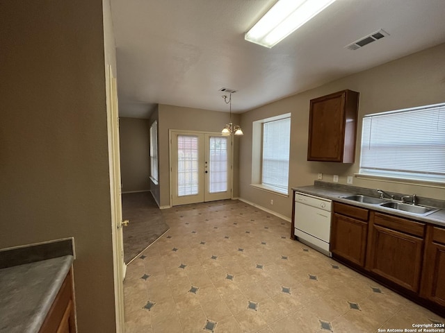 kitchen featuring decorative light fixtures, dark countertops, visible vents, a sink, and dishwasher